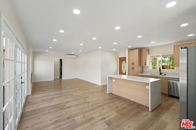 a large kitchen with stainless steel appliances granite countertop a stove and a refrigerator