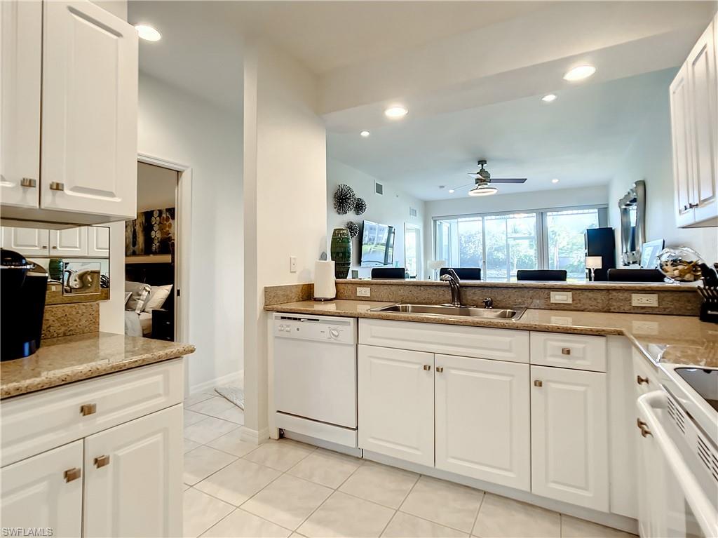 7930 Mahogany Run Lane, Unit 814 Naples, FL 34113 - Photo 14 of 29 a kitchen with white cabinets and sink