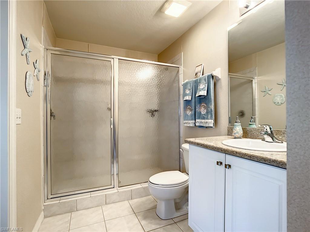 7930 Mahogany Run Lane, Unit 814 Naples, FL 34113 - Photo 15 of 29 a bathroom with a shower sink vanity mirror and toilet