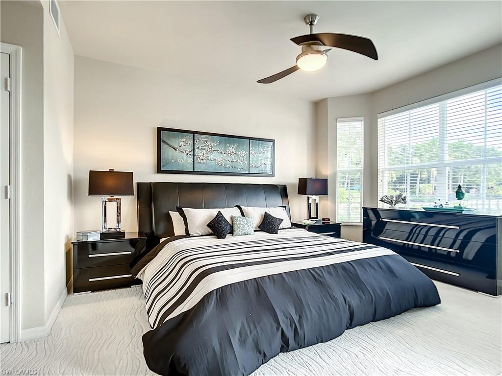 7930 Mahogany Run Lane, Unit 814 Naples, FL 34113 - Photo 18 of 29 a bedroom with a bed and wooden floor