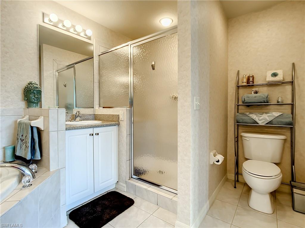 7930 Mahogany Run Lane, Unit 814 Naples, FL 34113 - Photo 21 of 29 a bathroom with a granite countertop sink toilet and shower