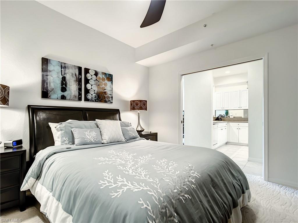 7930 Mahogany Run Lane, Unit 814 Naples, FL 34113 - Photo 22 of 29 a bedroom with a bed and a large mirror