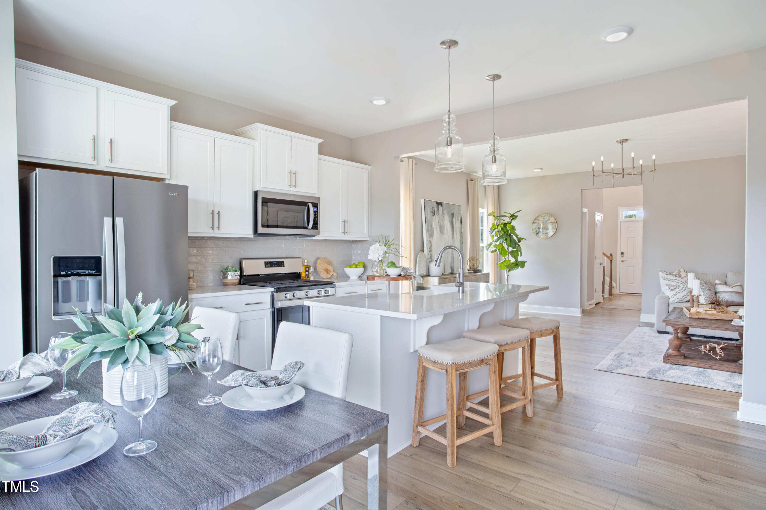 2011 Cross Bones Boulevard, Unit 41 Durham, NC 27703 - Photo 4 of 14 a kitchen with granite countertop stainless steel appliances a dining table chairs stove refrigerator and microwave