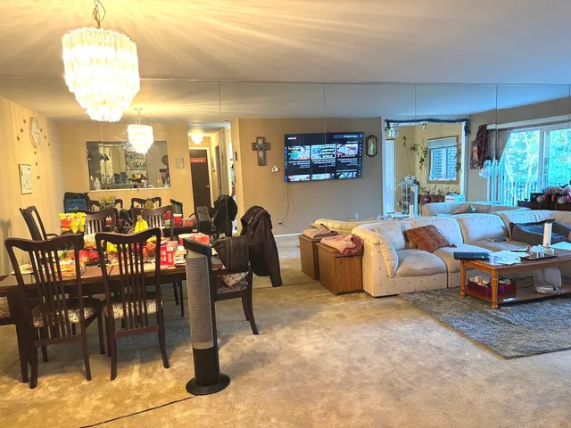 a living room with furniture a chandelier and a dining table
