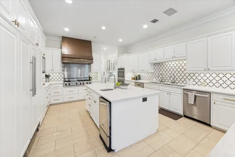 a kitchen with white cabinets appliances and sink
