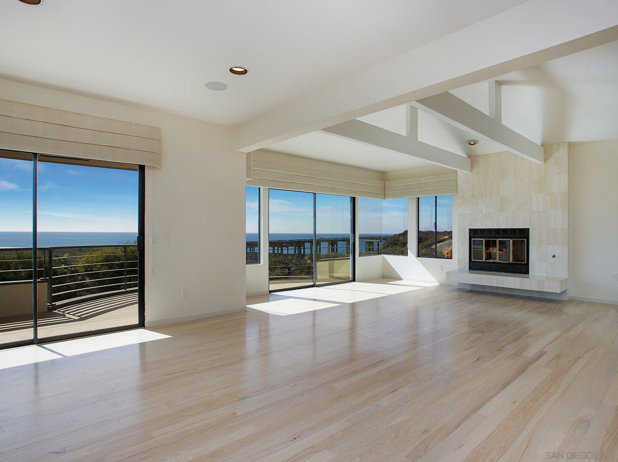 560 Torrey Point Road Del Mar, CA 92014 - Photo 6 of 25 an empty room with wooden floor and fireplace