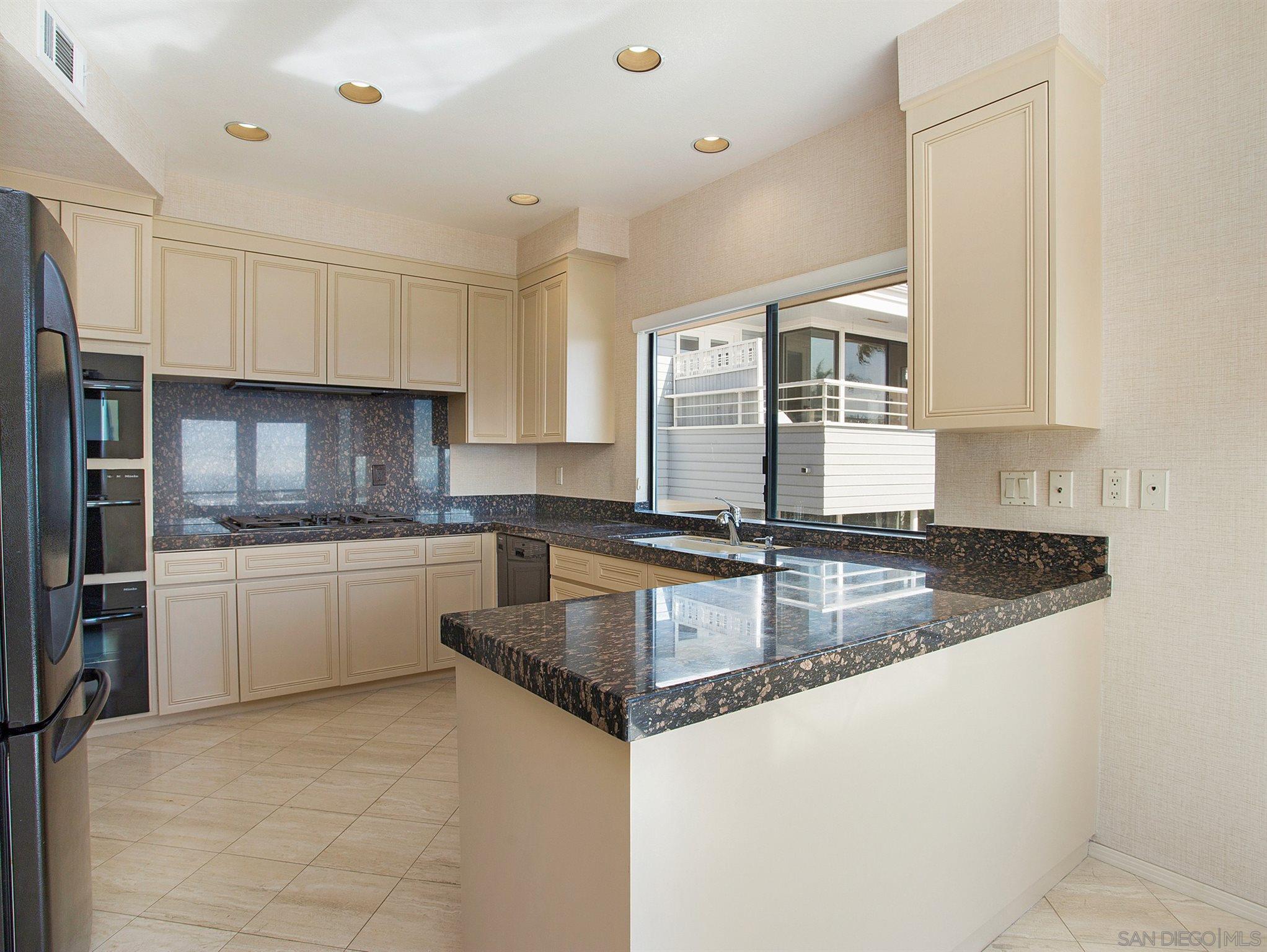 560 Torrey Point Road Del Mar, CA 92014 - Photo 8 of 25 a kitchen with stainless steel appliances granite countertop a sink stove and refrigerator