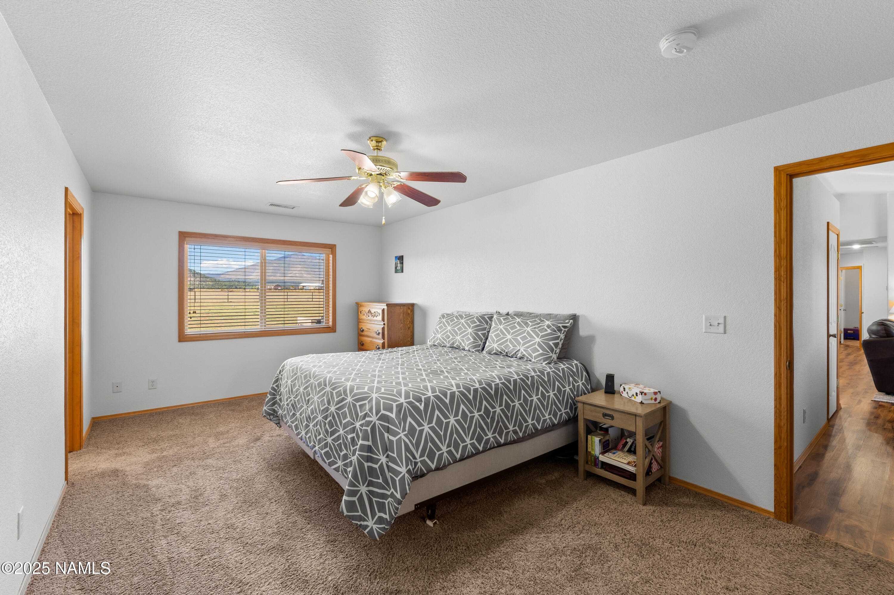 9662 North Aldrich Road Flagstaff, AZ 86004 - Photo 12 of 33 a bedroom with a bed and a chandelier