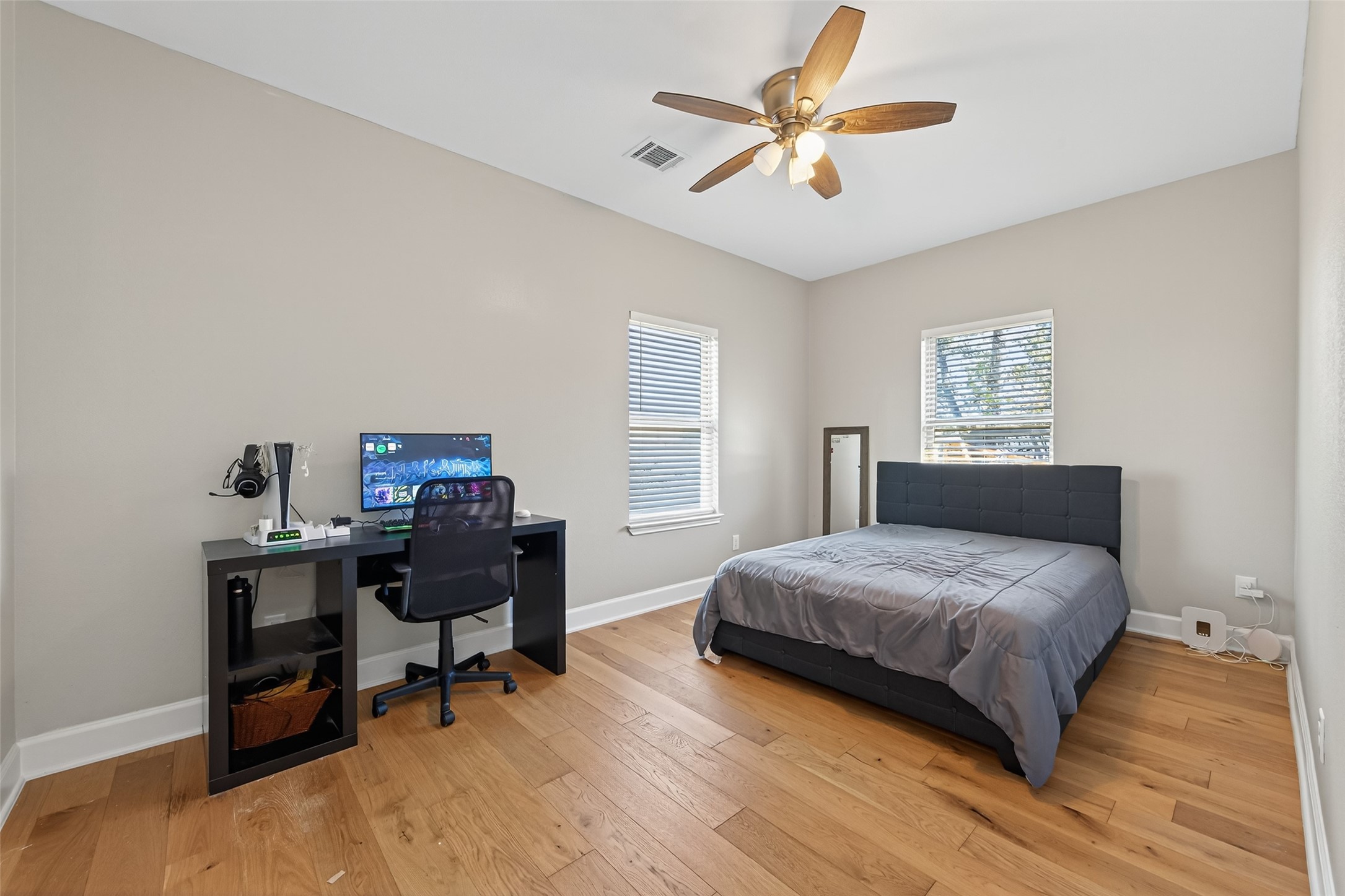 19477 Lazy Lane Porter, TX 77365 - Photo 22 of 26 a bedroom with a bed a desk and chair with wooden floor