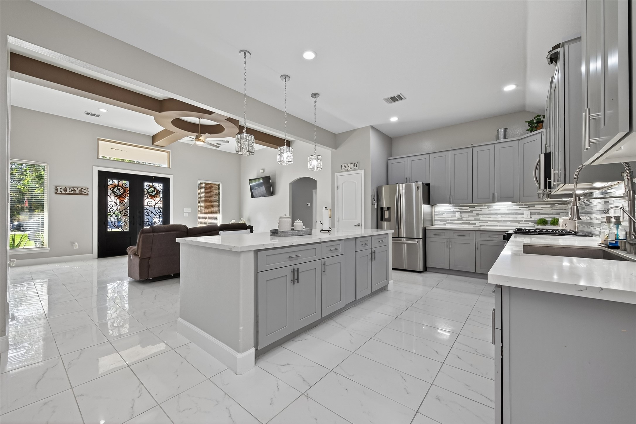 19477 Lazy Lane Porter, TX 77365 - Photo 7 of 26 a large white kitchen with kitchen island a sink a counter top space and stainless steel appliances