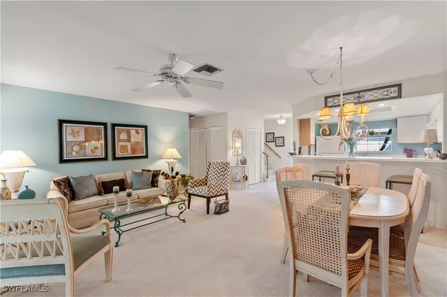 a living room with furniture a chandelier and a window