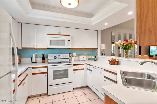 a kitchen with granite countertop white cabinets and white appliances