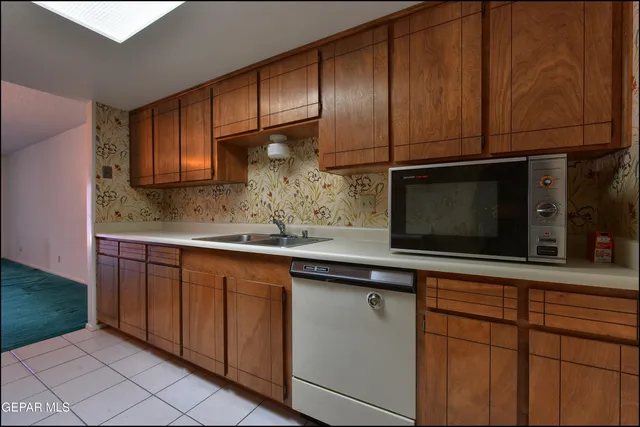 a kitchen with stainless steel appliances wooden cabinets and a microwave oven