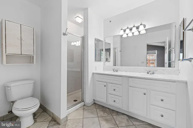 a bathroom with a granite countertop toilet sink and mirror