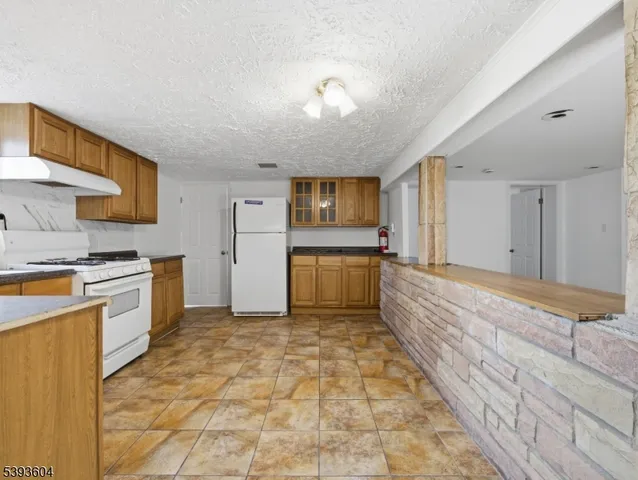 a large kitchen with stainless steel appliances granite countertop a stove a sink and a refrigerator