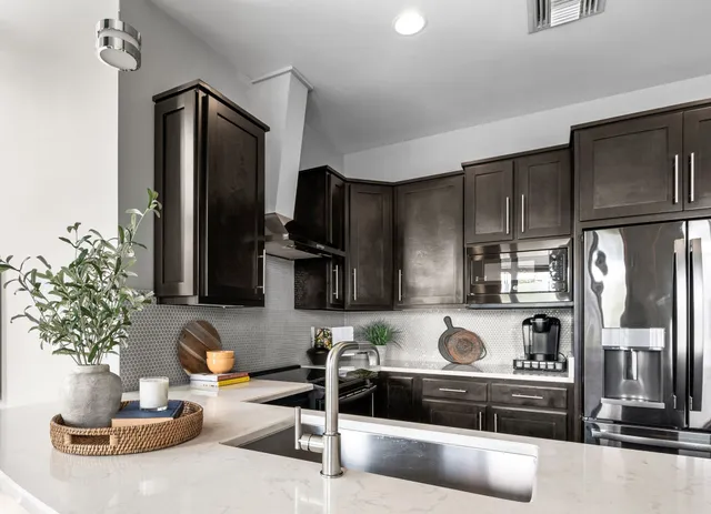 a kitchen with stainless steel appliances a refrigerator and wooden floor