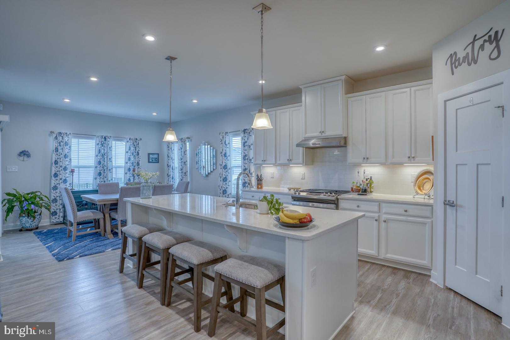 24077 Caldwell Circle Lewes, DE 19958 - Photo 15 of 60 a kitchen with a sink a stove a center island and chairs