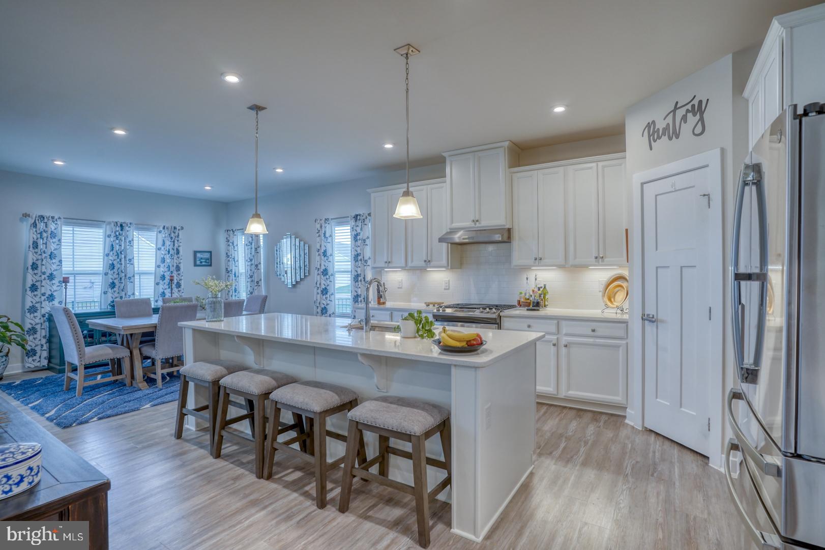 24077 Caldwell Circle Lewes, DE 19958 - Photo 17 of 60 a kitchen with a dining table chairs wooden floor and appliances
