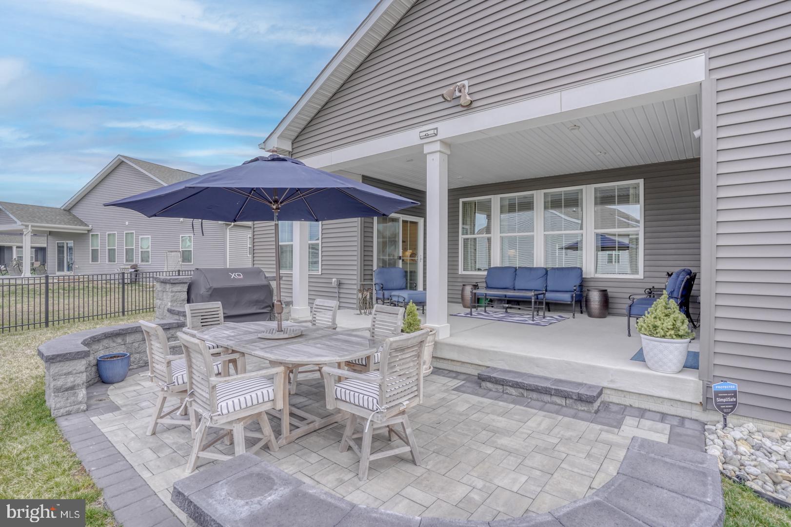 24077 Caldwell Circle Lewes, DE 19958 - Photo 5 of 60 a patio with a table and chairs under an umbrella