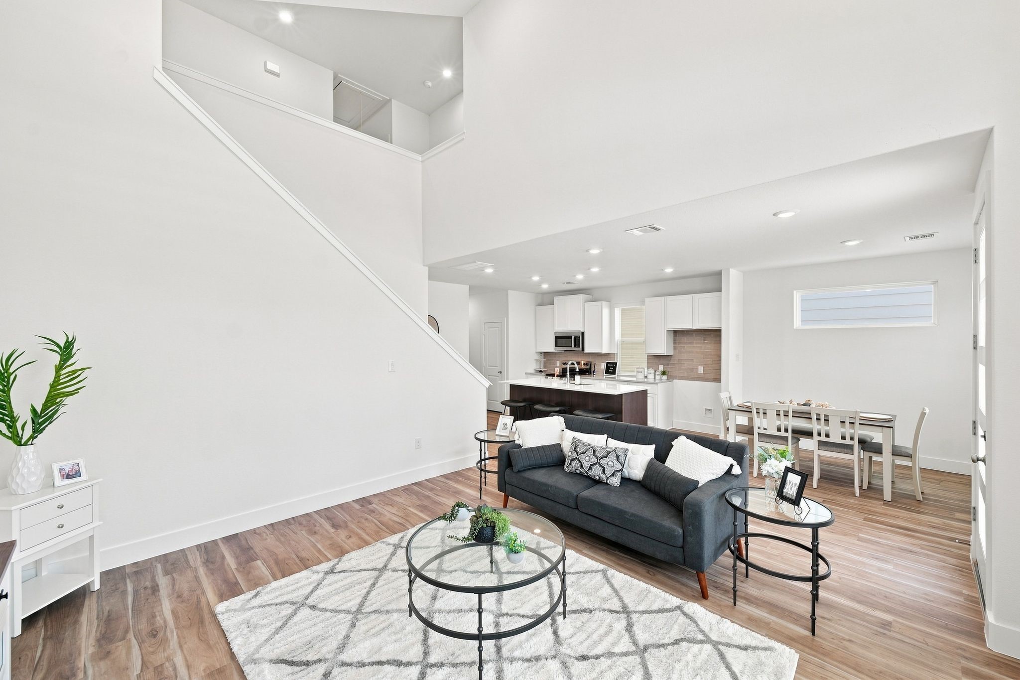 6063 Cebra Street Houston, TX 77091 - Photo 26 of 50 Spacious living room showcasing impressive ceiling height and an open-concept design with clear views into the kitchen and breakfast area. Photos are from a different property with the same floor plan, features, and finishes. **Orientation may vary.**