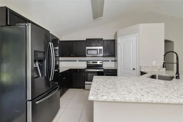 a kitchen with stainless steel appliances granite countertop a refrigerator and a sink
