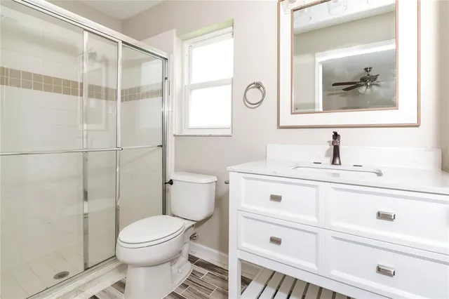 a bathroom with a toilet a sink a mirror and a shower