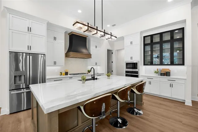 a kitchen with a table chairs refrigerator and cabinets