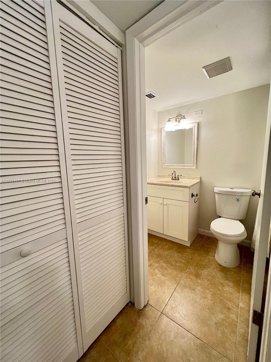 340 Pine Ridge Circle, Unit D1 Greenacres, FL 33463 - Photo 17 of 25 a bathroom with a toilet a sink and mirror
