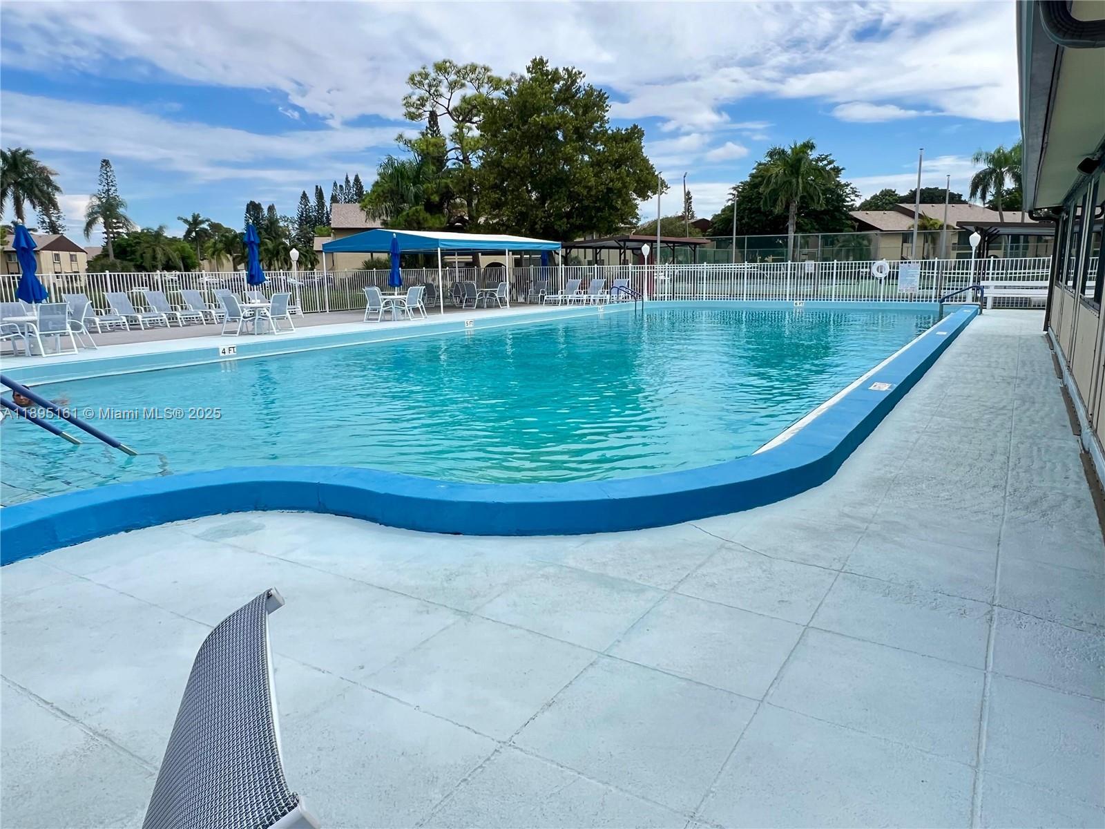 340 Pine Ridge Circle, Unit D1 Greenacres, FL 33463 - Photo 23 of 25 a view of a swimming pool with a lake view