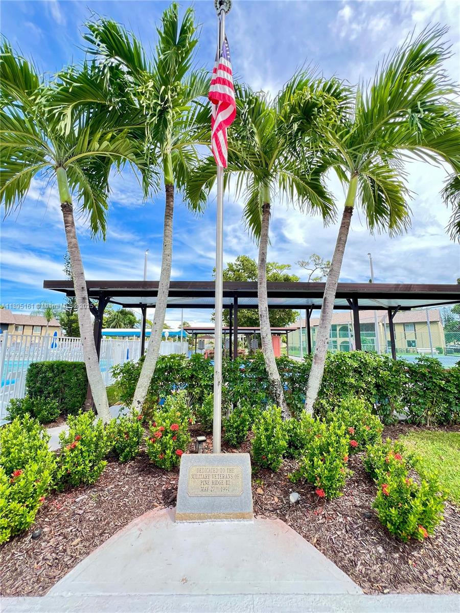 340 Pine Ridge Circle, Unit D1 Greenacres, FL 33463 - Photo 3 of 25 a plant in front of a house with a garden