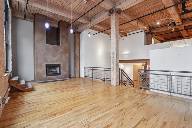 1000 West Washington Boulevard, Unit 137 Chicago, IL 60607 - Photo 5 of 33 a view of a livingroom with wooden floor and a fireplace