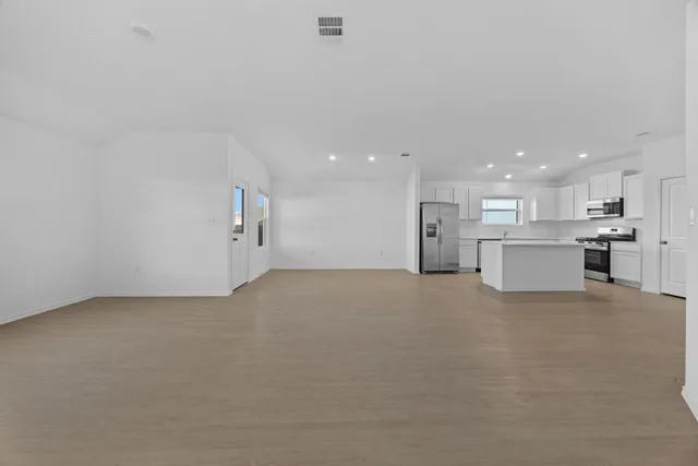 an empty room with windows and closet