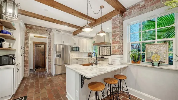 a living room with furniture a chandelier and a wooden floor
