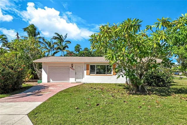 a front view of a house with a yard and trees