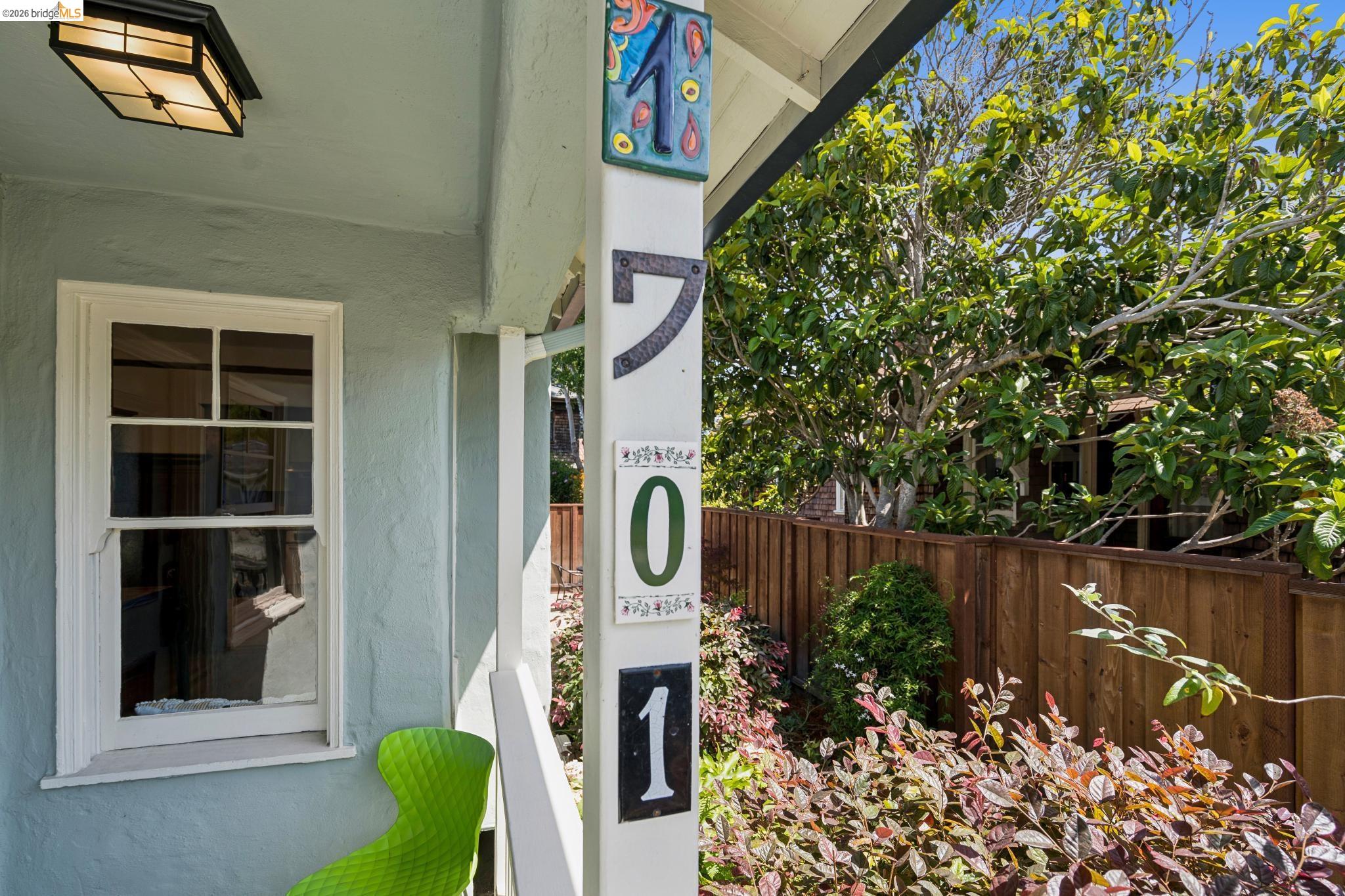 1701 Derby Street Berkeley, CA 94703 - Photo 6 of 39 Front porch entry featuring a decorative address column, stucco exterior finish, recessed ceiling light fixture, white-framed window, and mature landscaping with a wood privacy fence