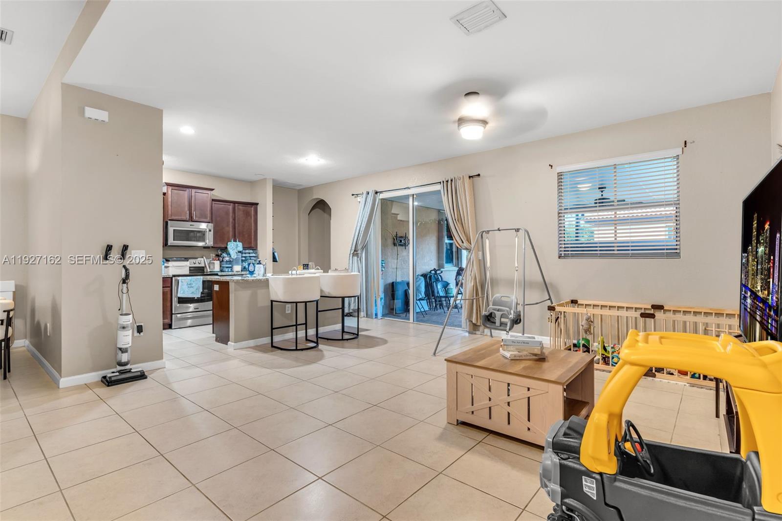 11833 Southwest 250th Terrace Homestead, FL 33032 - Photo 11 of 38 a living room with furniture and a flat screen tv
