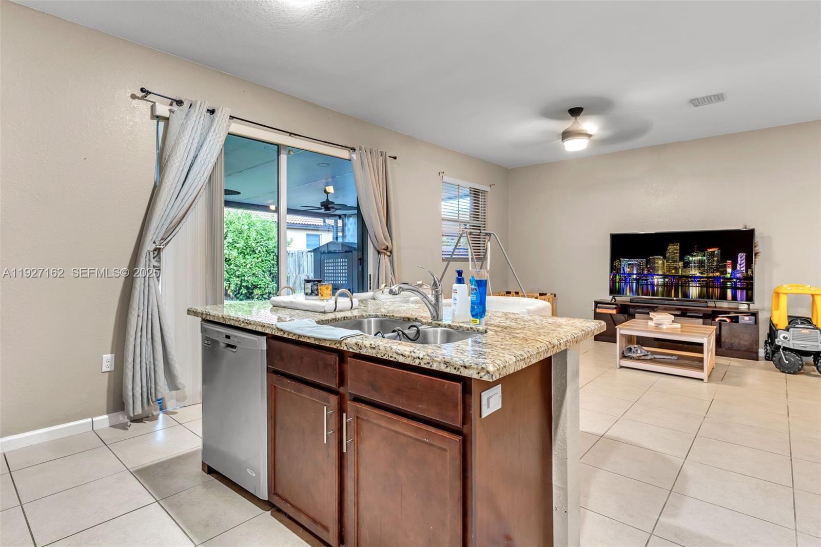 11833 Southwest 250th Terrace Homestead, FL 33032 - Photo 10 of 38 a kitchen with stainless steel appliances granite countertop a sink and a refrigerator