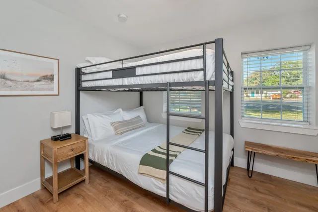 a kitchen with stainless steel appliances granite countertop a stove top oven a sink dishwasher a dining table and chairs with wooden floor