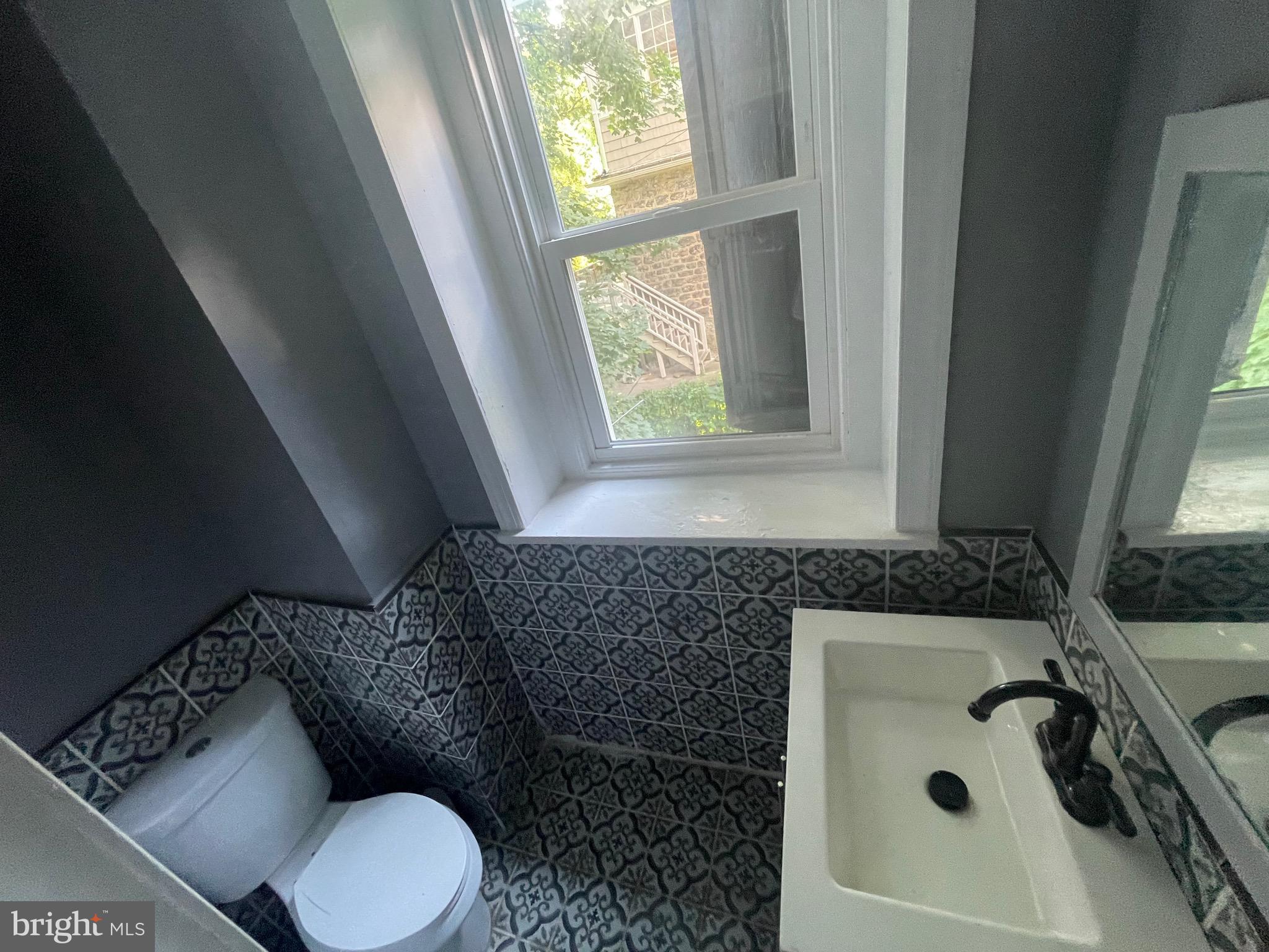 6416 Overbrook Avenue Philadelphia, PA 19151 - Photo 10 of 18 a bathroom with a granite countertop sink mirror vanity and toilet