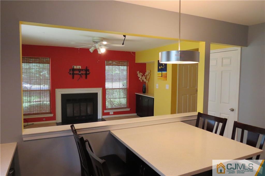 908 Timber Oaks Road Edison, NJ 08820 - Photo 8 of 20 a kitchen with a table chairs and a fireplace