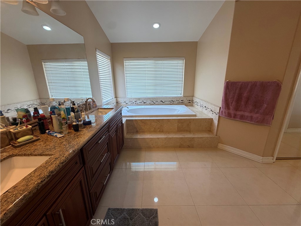 19823 Mariposa Pines Way Porter Ranch, CA 91326 - Photo 27 of 50 a bathroom with a tub a sink and a large window