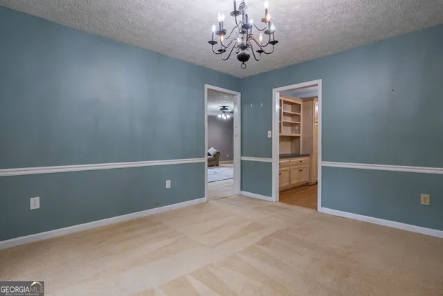 an empty room with closet and a chandelier fan
