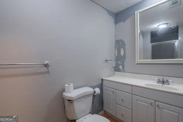 a backyard of a house with wooden fence and large trees