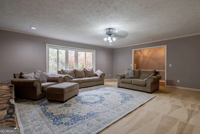 a living room with a bed furniture and two windows