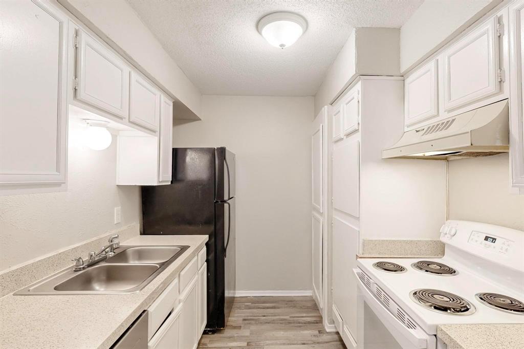 9696 Walnut Street, Unit 1402 Dallas, TX 75243 - Photo 21 of 33 a kitchen that has a sink a refrigerator and cabinets