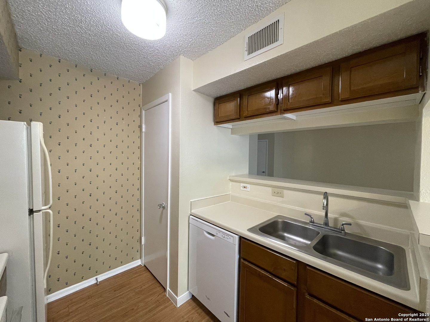 11311 Sir Winston Street, Unit 604 San Antonio, TX 78216 - Photo 11 of 24 a kitchen with a sink and a refrigerator