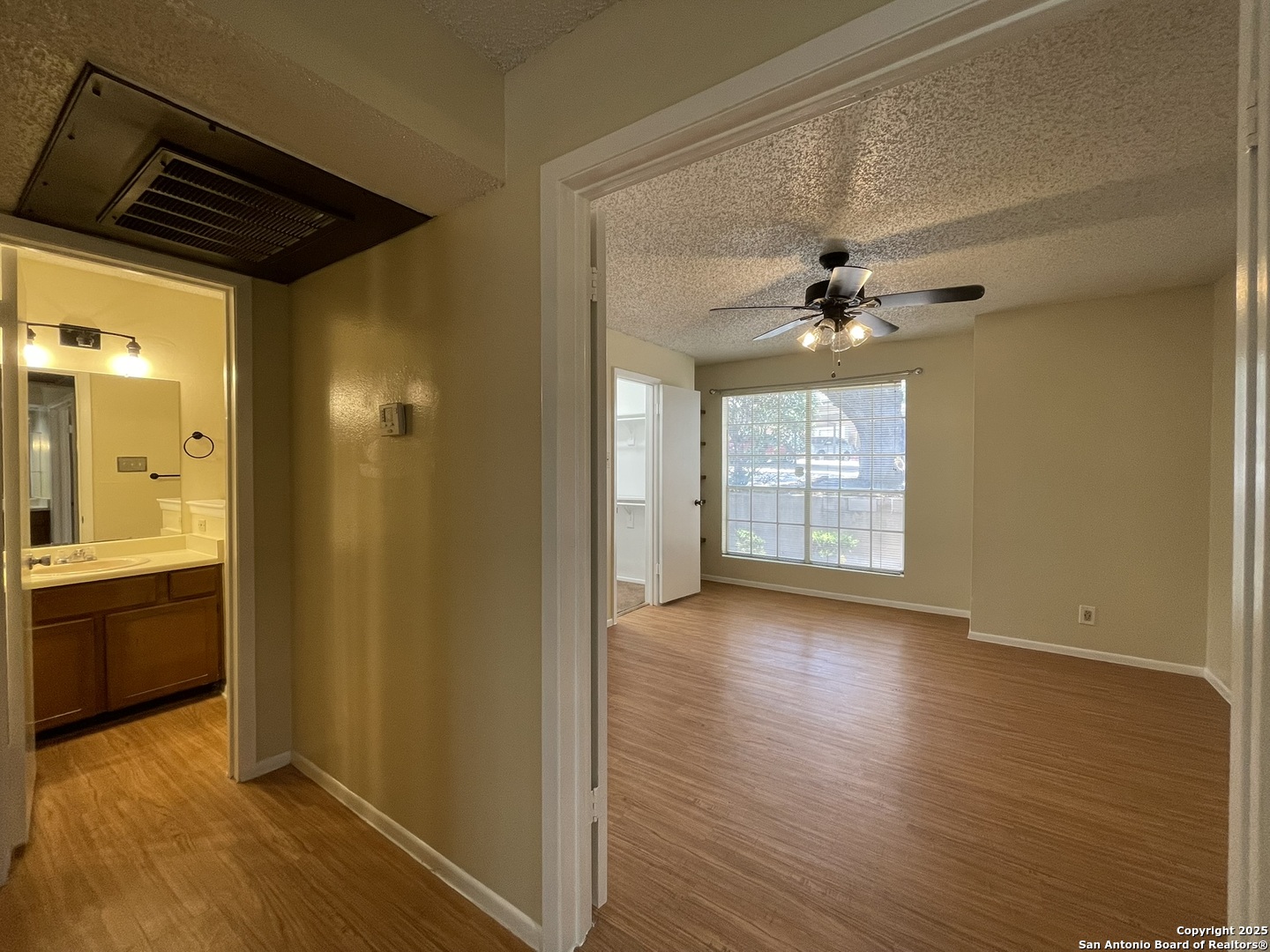 11311 Sir Winston Street, Unit 604 San Antonio, TX 78216 - Photo 14 of 24 a view of an empty room with wooden floor and a window