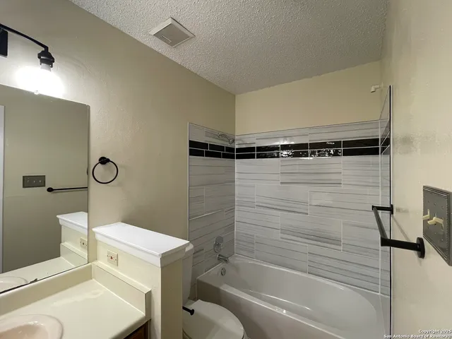a bathroom with a shower a mirror and a toilet
