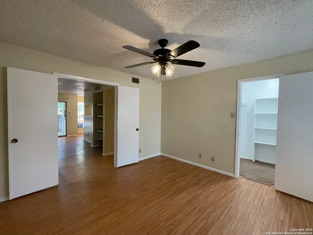 a view of an empty room with window and wooden floor