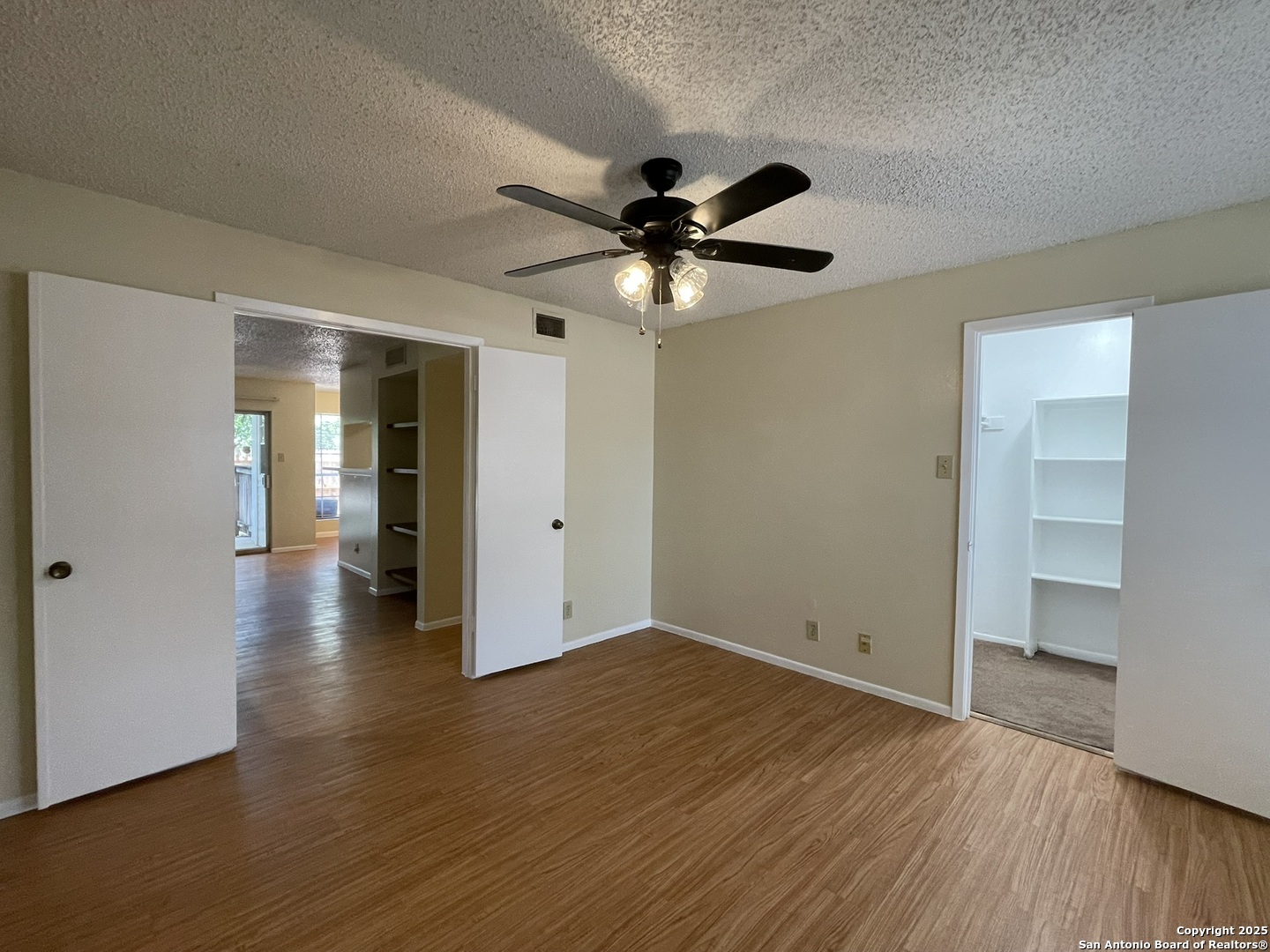 11311 Sir Winston Street, Unit 604 San Antonio, TX 78216 - Photo 19 of 24 a view of an empty room with window and wooden floor